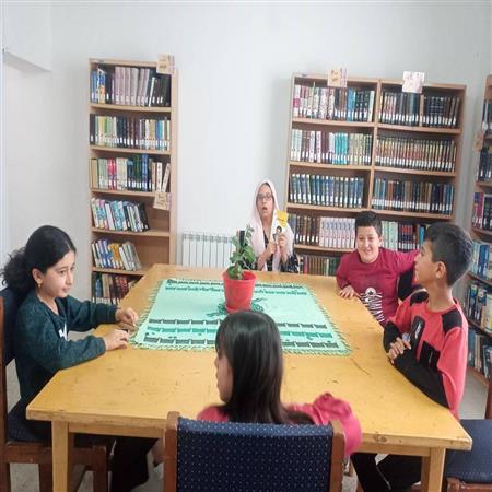 جمع خوانی کتاب توسط عضو کتابخانه در کتابخانه عمومی شهدای الاشت